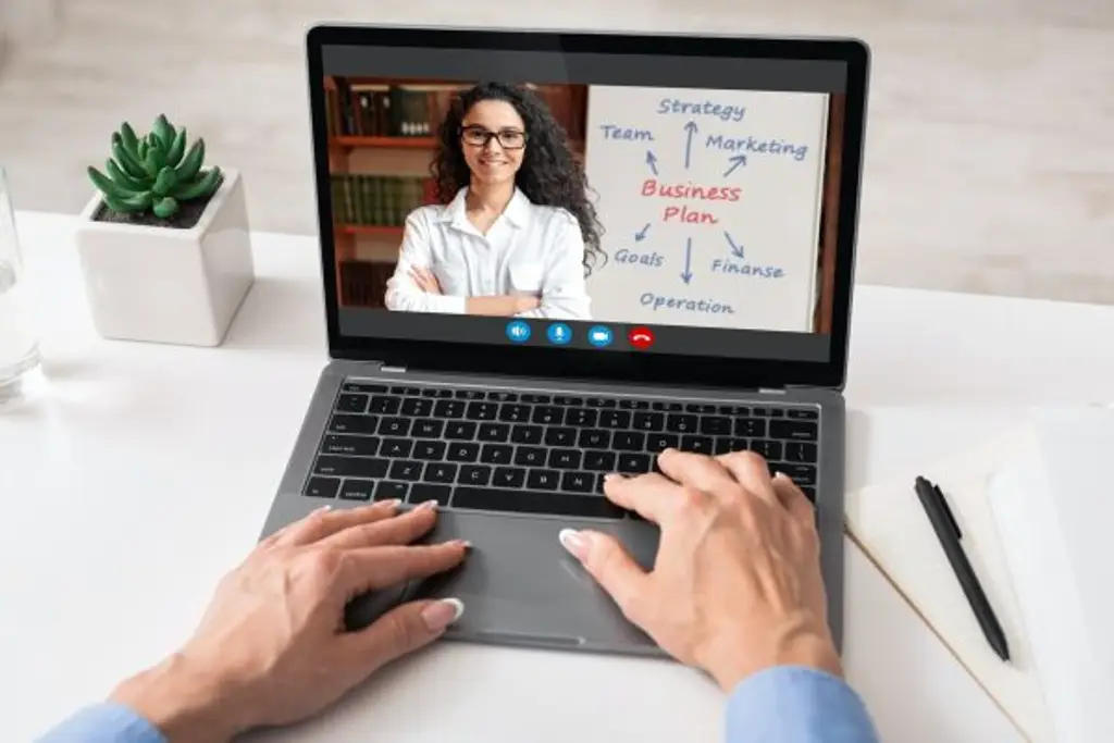 Unrecognizable woman having video call with business coach, using laptop